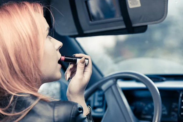 Flicka göra make up när du kör bilen. — Stockfoto