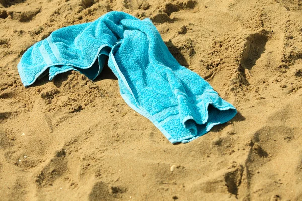 Toalha azul em uma praia de areia . — Fotografia de Stock