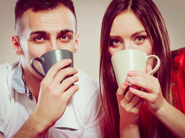 Joven divertida pareja bebiendo té o café — Foto de Stock