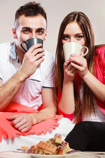 Молодая веселая пара пьет чай или кофе — стоковое фото