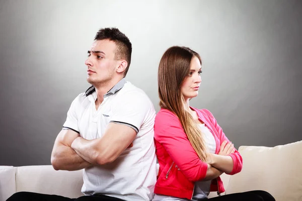 Young couple after quarrel sitting on sofa back to back — Stock Photo, Image