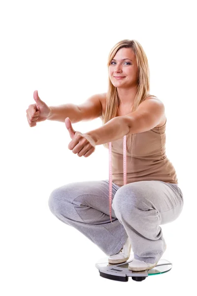 Girl on scales celebrating weightloss — Stock Photo, Image