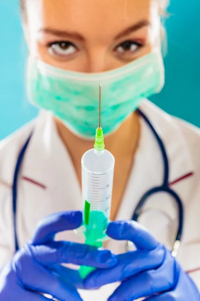 Doctor in de masker houdt van de spuit — Stockfoto