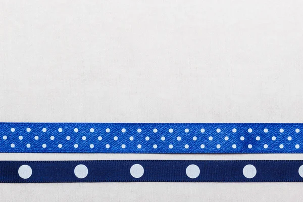 Голубая лента на белой ткани — стоковое фото