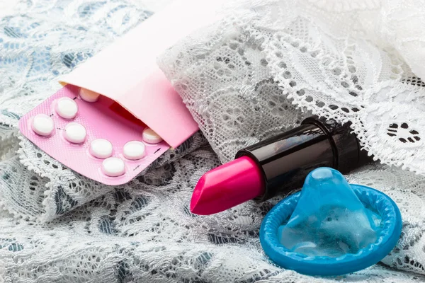 Pills, condom and lipstick — Stock Photo, Image