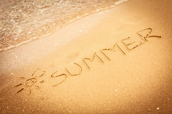 Woord zomer geschreven in het zand op een strand — Stockfoto