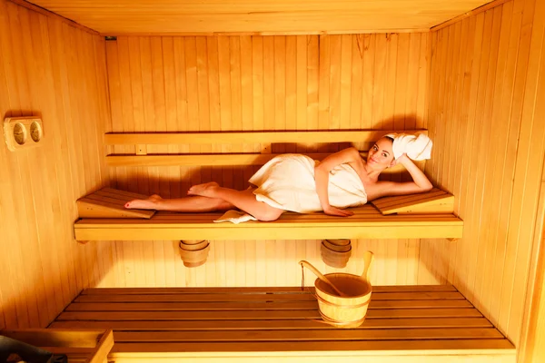 Mulher deitada na sauna de madeira — Fotografia de Stock