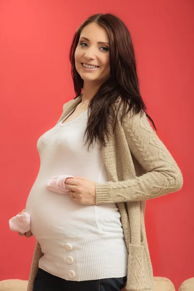 Pregnant woman holding shoes — Stock Photo, Image