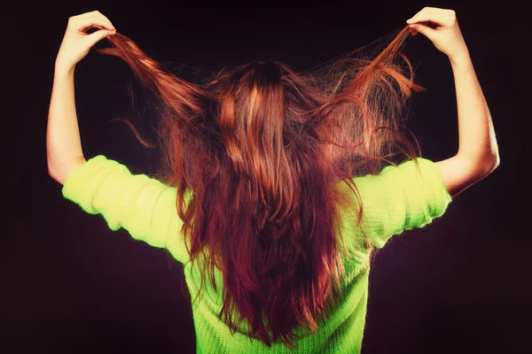 Jovem mulher puxando seu cabelo longo. — Fotografia de Stock