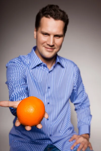 Homem segurando laranja — Fotografia de Stock