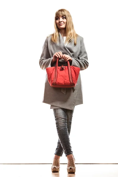 Kvinna i grå kappa håller röd handväska — Stockfoto