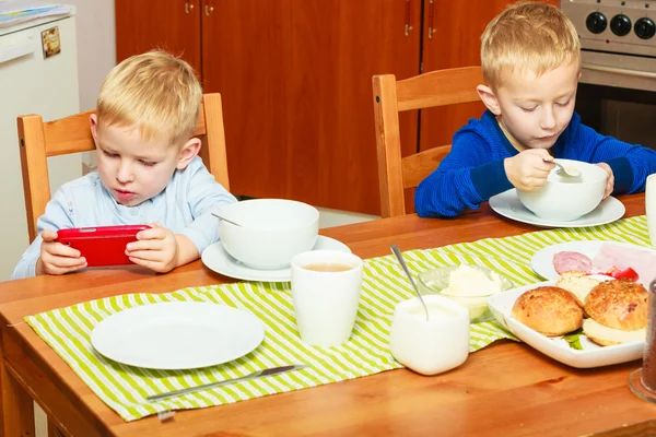 Two boys eating breakfast at home — Stock Photo, Image