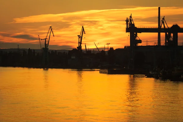 Grande grue de chantier naval au coucher du soleil à Gdansk, Pologne . — Photo