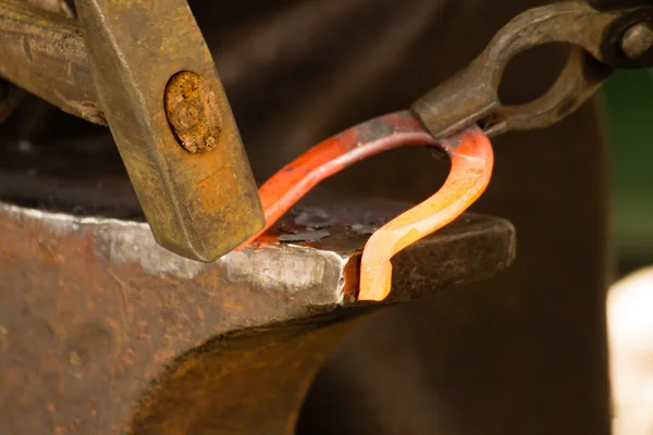 Fabbro forgia un ferro di cavallo caldo . — Foto Stock