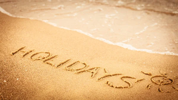 A word ünnepek írt a homok a tengerparton — Stock Fotó