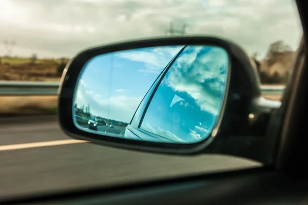 Coche en la carretera y espejo retrovisor — Foto de Stock