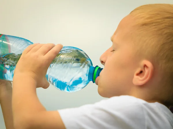 Bambino che beve acqua dalla bottiglia di plastica — Foto Stock