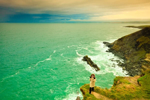 Irish atlantic coast. Woman tourist standing on rock cliff — Stock Photo, Image