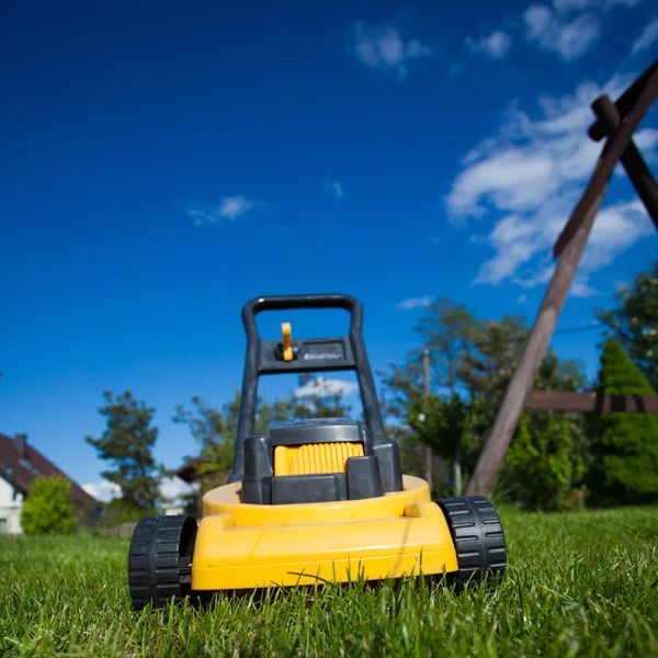 Jardinagem. Cortando gramado com cortador de grama amarelo — Fotografia de Stock
