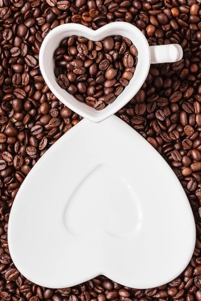 Tasse und Untertasse auf Kaffeebohnen Hintergrund — Stockfoto