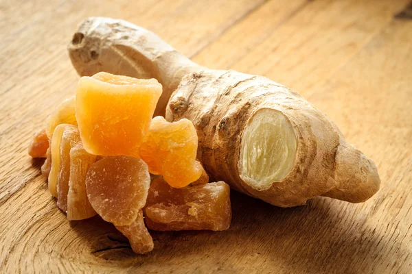 Closeup root and candied ginger on wooden table — Stock Photo, Image