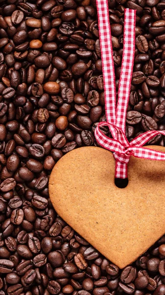 Heart shaped cookie on coffee beans background — Stock Photo, Image