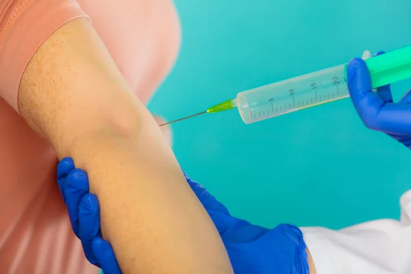 Läkare med spruta att ge injektion till patienten. — Stockfoto