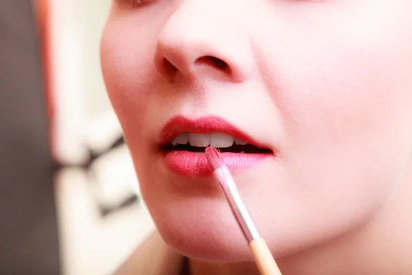 Mujer aplicando lápiz labial rojo — Foto de Stock