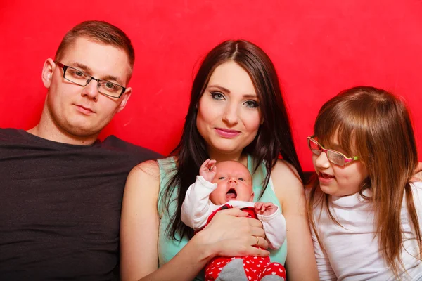 Familia joven sentada en un sofá — Foto de Stock