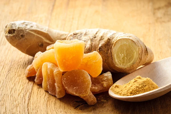 Candied fresh and ground ginger on rustic table — Stock Photo, Image