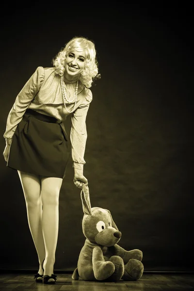 Mulher segurando grande cão brinquedo — Fotografia de Stock