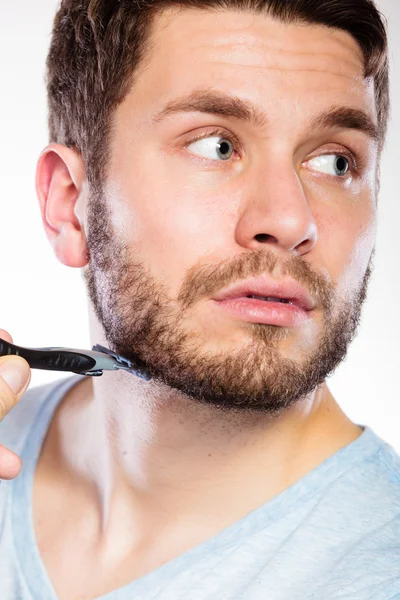 Jovem com barba segurando lâmina de barbear — Fotografia de Stock