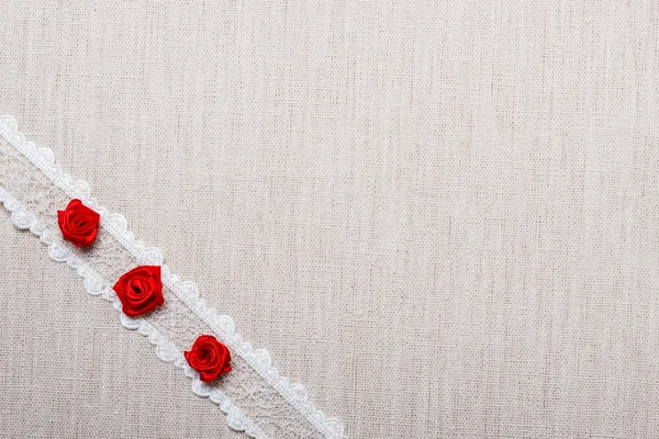 Marco de rosas de seda roja sobre tela — Foto de Stock