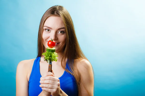 Niña sosteniendo tenedor con verduras — Foto de Stock