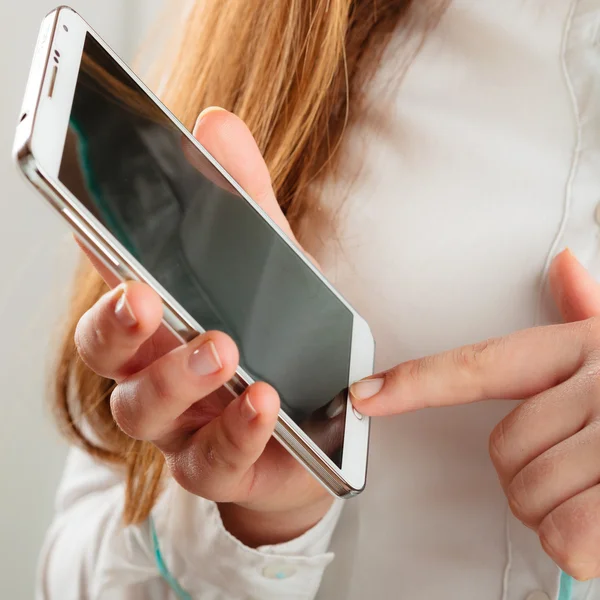 Dívka drží v ruce mobilní telefon — Stock fotografie
