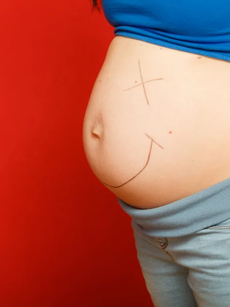 Gravid kvinna med målade glad smiley face-mage — Stockfoto