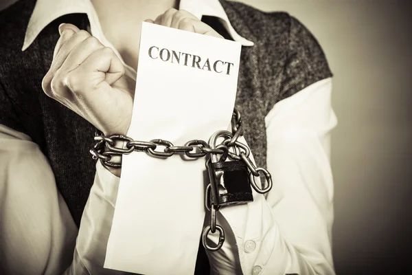 Businesswoman with chained hands holding contract — Stock Photo, Image