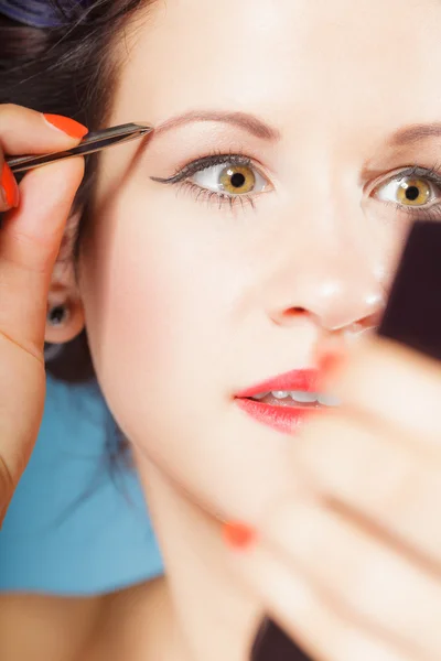 Girl tweezing eyebrows — Stock Photo, Image