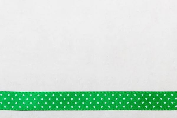 Dotted green ribbon frame on white cloth — Stock Photo, Image