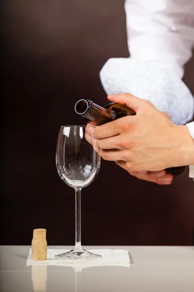 Man ober gieten van witte wijn in glas. — Stockfoto