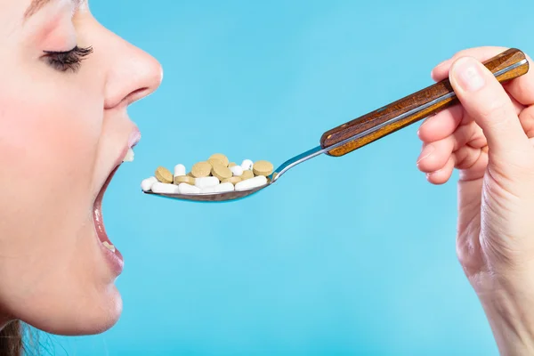 Young woman eating pills — Stock Photo, Image