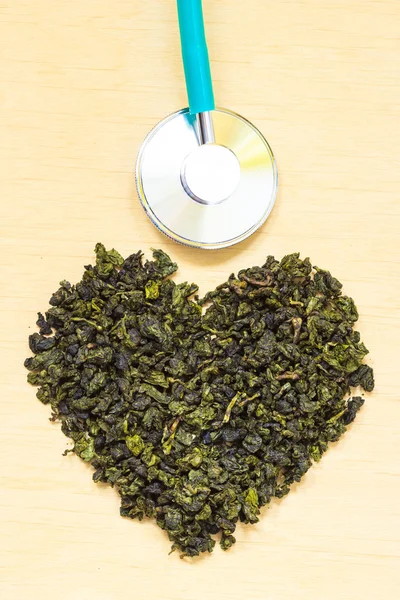Zelený čaj listy srdce ve tvaru a stetoskop — Stock fotografie