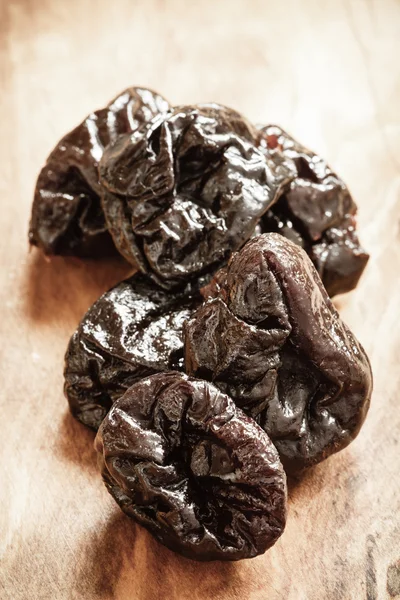 Dried plums prunes on wooden table — Stock Photo, Image