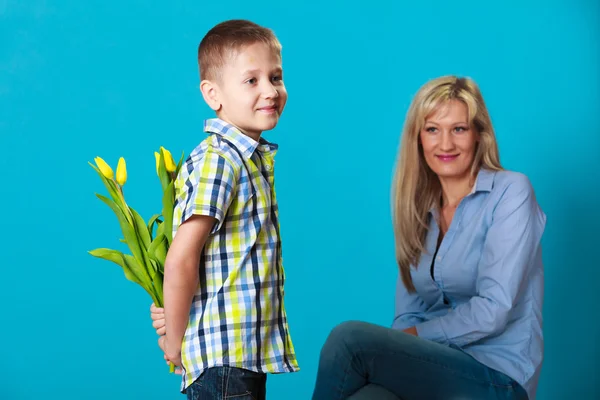 Dziecko chłopiec dając kwiaty jego matka — Zdjęcie stockowe