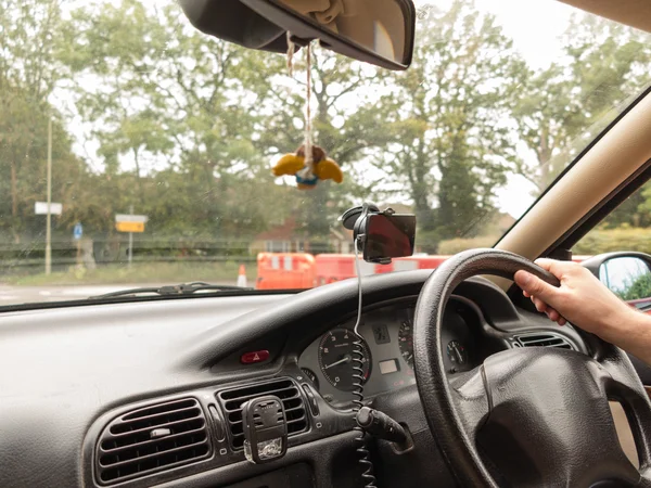 Manos de conductor masculino sosteniendo el volante de un coche — Foto de Stock