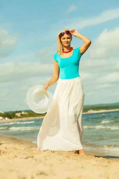 Дівчина з капелюхом позує на пляжі — стокове фото