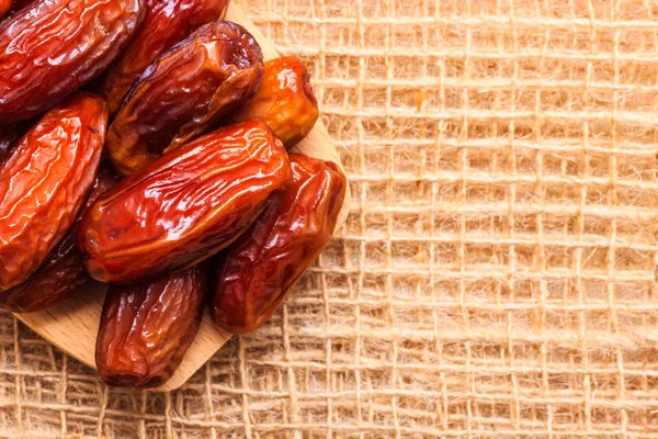 Dried dates on wooden spoon cloth background — Stock Photo, Image