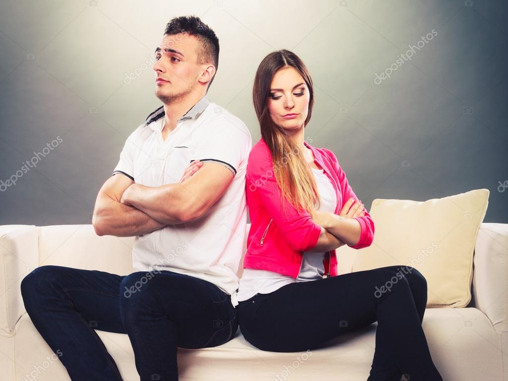 Bad relationship concept. Man and woman in disagreement. Young couple after quarrel sitting on sofa back to back
