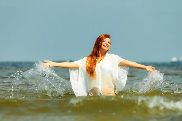 Vacaciones. Chica chapoteando agua divirtiéndose en el mar . — Foto de Stock