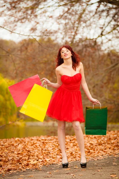 Outono mulher comprador com sacos de venda ao ar livre no parque — Fotografia de Stock